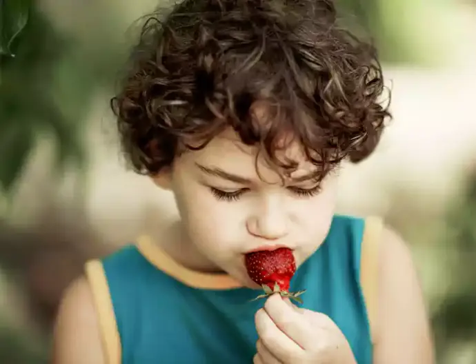 Niño disfruta de su fruta.